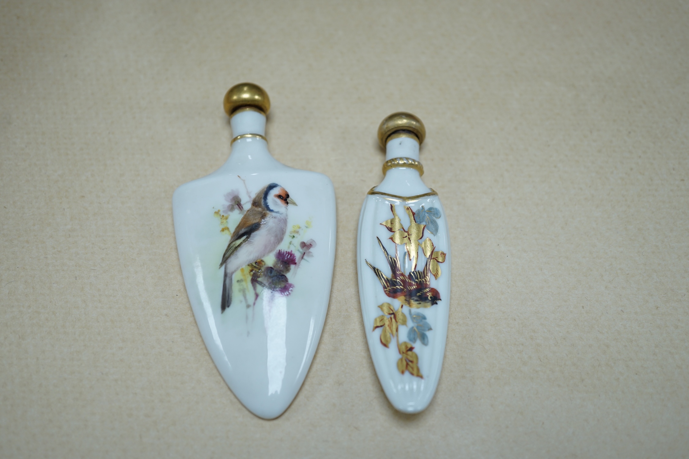 An unusual Royal Worcester bird painted scent flask and another similar flask, longest 10cm. Condition - cork to one stopper broken, unsigned